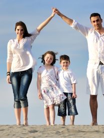 happy young family have fun on beachand showing home sign with conncected hands while protecting childrens